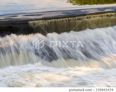 A small flat cascade in a calm river 139943474