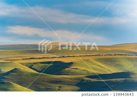 Layers of green mountains and hills in the haze during sunset. Panoramic View of Green hills and Meadow. 139943643
