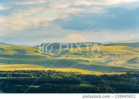 Layers of green mountains and hills in the haze during sunset. Panoramic View of Green hills and Meadow. 139943651