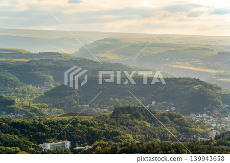 Layers of green mountains and hills in the haze during sunset. Panoramic View of Green hills and Meadow. 139943658