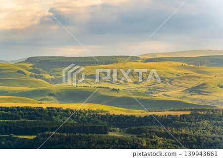 Layers of green mountains and hills in the haze during sunset. Panoramic View of Green hills and Meadow. 139943661