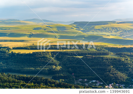 Layers of green mountains and hills in the haze during sunset. Panoramic View of Green hills and Meadow. Layers of green mountains and hills in the haze during sunset. Panoramic View of Green hills and Meadow. 139943691