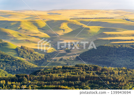 Layers of green mountains and hills in the haze during sunset. Panoramic View of Green hills and Meadow. 139943694