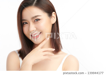 A beautiful young Asian woman with clean, fresh skin against a white background. Skincare, facial treatment, cosmetology, beauty, and spa. An elegant portrait of an Asian woman. 139944177