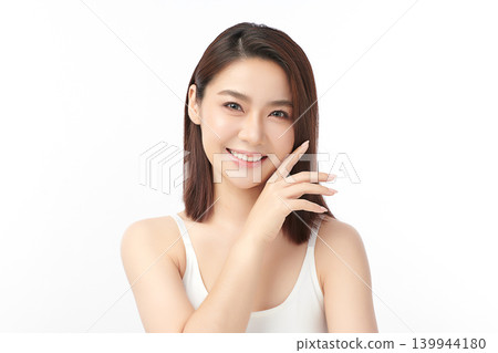 A beautiful young Asian woman with clean, fresh skin against a white background. Skincare, facial treatment, cosmetology, beauty, and spa. An elegant portrait of an Asian woman. 139944180