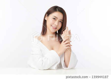 A beautiful young Asian woman with clean, fresh skin against a white background. Skincare, facial treatment, cosmetology, beauty, and spa. An elegant portrait of an Asian woman. 139944187