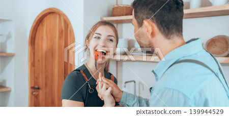 Happy couple cooking together in a cozy kitchen Happy couple cooking together in a cozy kitchen 139944529