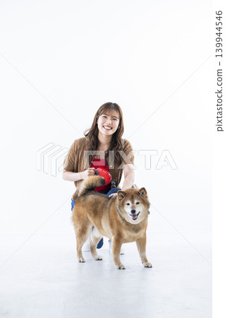 A Shiba Inu and a young woman against a white background. 139944546