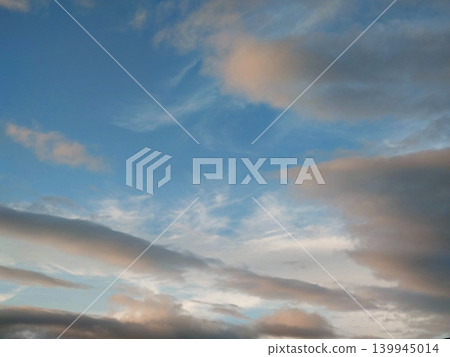A landscape of soft clouds and blue sky spreading across the evening sky. A landscape of soft clouds and blue sky spreading across the evening sky. 139945014
