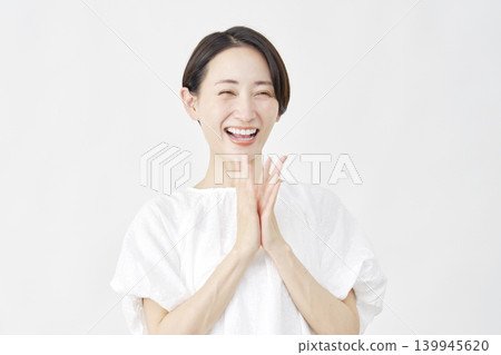 一位中年婦女在白色背景前鼓掌。 139945620