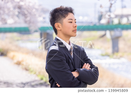 一名男學生驕傲地站著，雙手交叉抱在胸前。 139945809