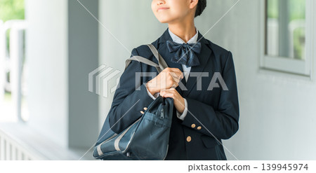 Junior high and high school girls in uniform walking in a school hallway Junior high and high school girls in uniform walking in a school hallway 139945974
