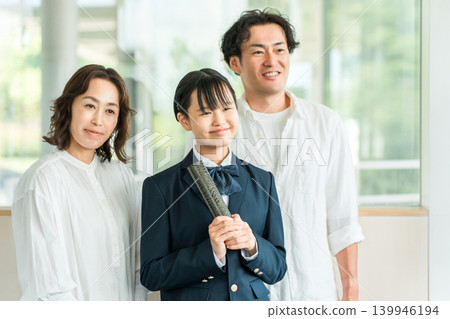 Middle school girl and parents holding a diploma Middle school girl and parents holding a diploma 139946194