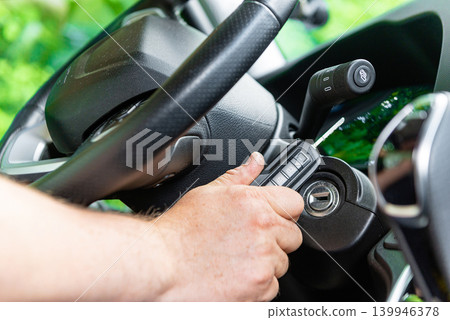 Driver hand turning key in car ignition photo Driver hand turning key in car ignition photo 139946378