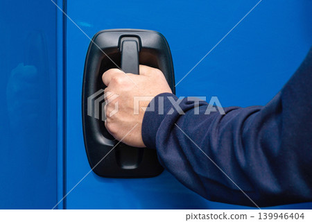 Hand pulling blue truck door handle close up Hand pulling blue truck door handle close up 139946404