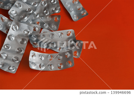 Close-up of used empty blister packs from pills on a bright red background. Close-up of used empty blister packs from pills on a bright red background. 139946696