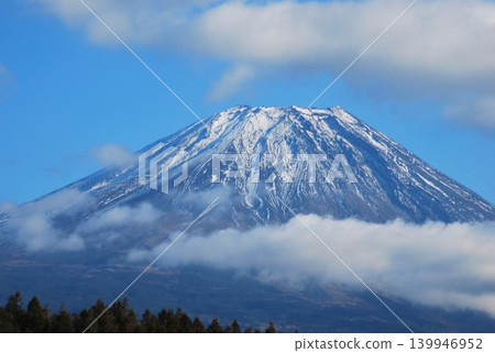 富士山巍峨聳立在晴朗的冬日天空下，雲霧繚繞。 139946952