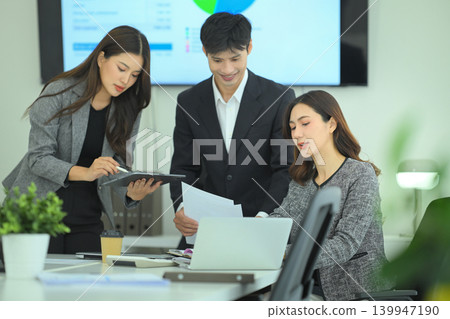 Business team reviewing strategy on laptop during meeting 139947190
