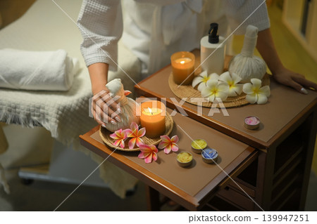 Top view spa setup with herbal compress candles flowers and relaxing wellness mood Top view spa setup with herbal compress candles flowers and relaxing wellness mood 139947251