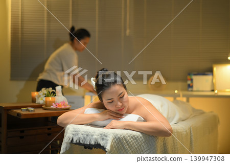 Woman relaxing during spa massage in warm wellness room with calm peaceful mood Woman relaxing during spa massage in warm wellness room with calm peaceful mood 139947308