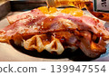 A close-up of a bacon and fried egg waffle with maple syrup poured over it. 139947554