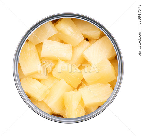 Canned pineapple chunks, in an opened tin can. Ripe pineapples, cut into block shaped pieces, boiled in own juice, and preserved. Isolated, close-up, from above, on white background, food photo. 139947575
