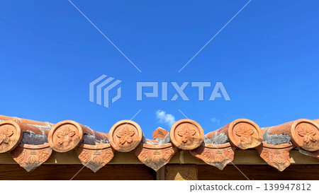 Okinawan red tile roofs and blue sky copy space background Okinawan red tile roofs and blue sky copy space background 139947812