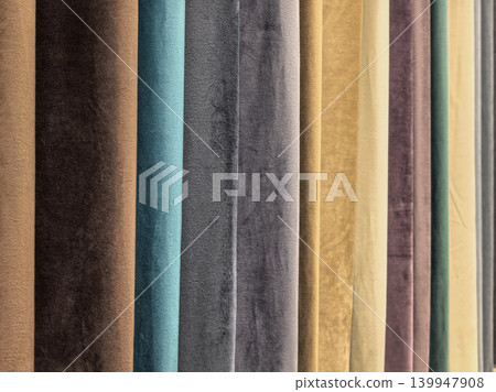 Velvet curtain fabric samples in various colors hanging in showroom Velvet curtain fabric samples in various colors hanging in showroom 139947908