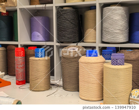 Industrial yarn cones and thread bobbins in textile workshop Industrial yarn cones and thread bobbins in textile workshop 139947910