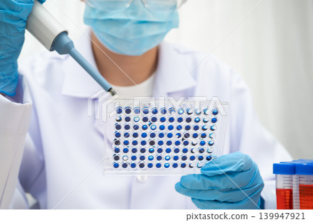 Scientist with cell culture in sample micro plate for research in science laboratory. Scientist with cell culture in sample micro plate for research in science laboratory. 139947921
