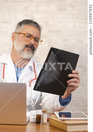 Doctor examining mammogram for breast cancer screening diagnosis Doctor examining mammogram for breast cancer screening diagnosis 139947932