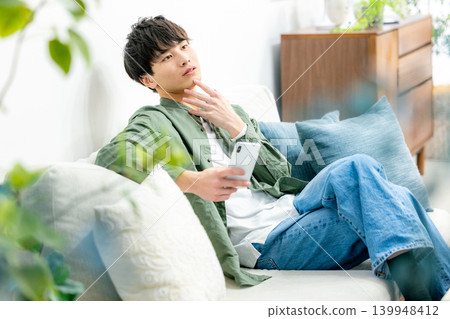 A young man looking at his smartphone A young man looking at his smartphone 139948412