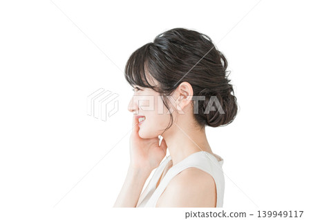 一位擁有美麗肌膚的亞洲女性的側面照（E字線、下顎線），她正在保養自己的皮膚。 139949117
