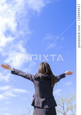 A back view of an office lady raising her arms in a victory pose (with an empty background). A back view of an office lady raising her arms in a victory pose (with an empty background). 139949417