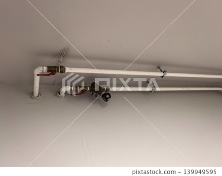 Close Up of Water Pipes and Valves on White Ceiling Close Up of Water Pipes and Valves on White Ceiling 139949595