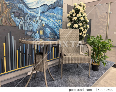 Wicker bistro table and chair set in decorated showroom with art wall Wicker bistro table and chair set in decorated showroom with art wall 139949600