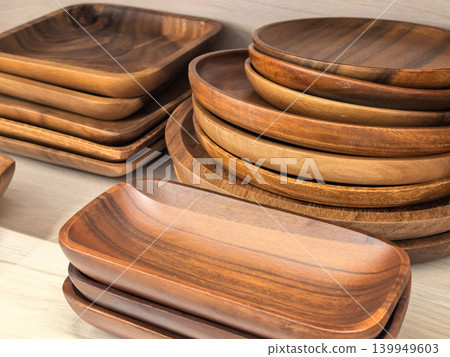 Handcrafted wooden serving plates and trays displayed in various shapes 139949603