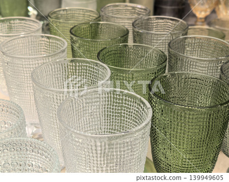 Modern textured glass tumblers in green and clear colors closeup view Modern textured glass tumblers in green and clear colors closeup view 139949605