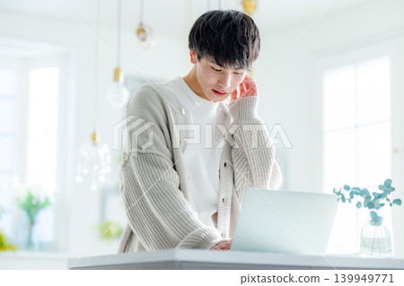 A man thinking while looking at his computer. A man thinking while looking at his computer. 139949771