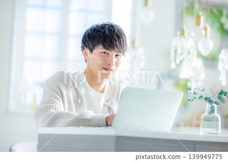 一個男人一邊看著電腦一邊思考。 139949775