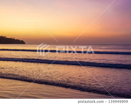 Twilight sky with yellow and purple gradient over ocean waves at Jimbaran Beach, Bali, Indonesia 139949909
