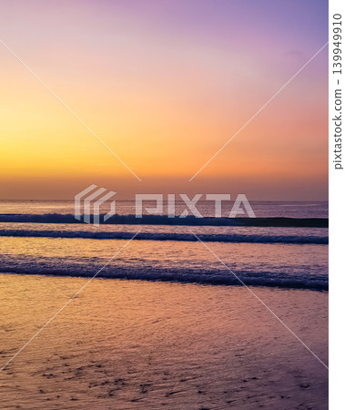 Twilight sky with yellow and purple gradient over ocean waves at Jimbaran Beach, Bali, Indonesia Twilight sky with yellow and purple gradient over ocean waves at Jimbaran Beach, Bali, Indonesia 139949910