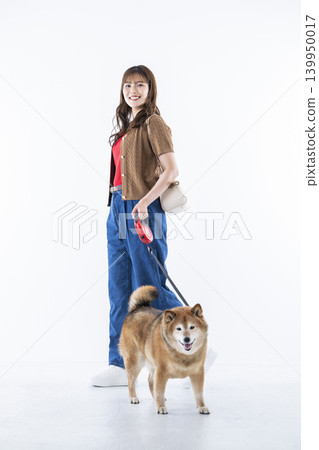 A young woman walking with a Shiba Inu on a white background 139950017