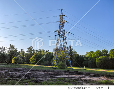 High voltage power line pylon in green park landscape with muddy tracks High voltage power line pylon in green park landscape with muddy tracks 139950210