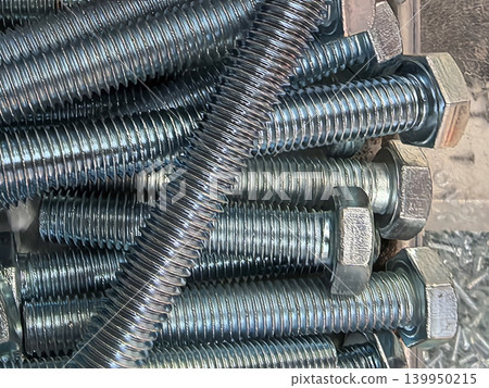 Galvanized hex head bolts with zinc coating stacked together closeup Galvanized hex head bolts with zinc coating stacked together closeup 139950215