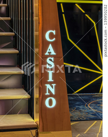 Illuminated casino sign on wooden column near staircase entrance Illuminated casino sign on wooden column near staircase entrance 139950282