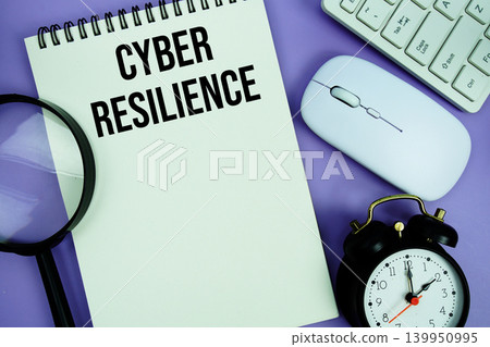 Notepad with the text "Cyber Resilience" and white keyboard, wireless mouse, magnifying glass and alarm clock Notepad with the text "Cyber Resilience" and white keyboard, wireless mouse, magnifying glass and alarm clock 139950995