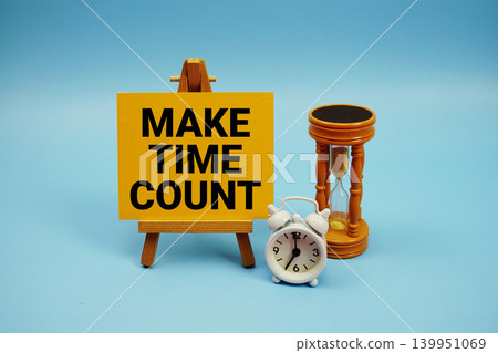 Make Time Count text with alarm clock and hourglass on blue background 139951069