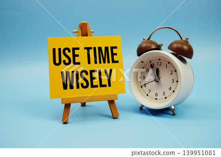 Use Time Wisely text with alarm clock on blue background Use Time Wisely text with alarm clock on blue background 139951081