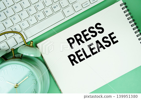 Notepad with the text "Press Release" with white keyboard and alarm clock on green background Notepad with the text "Press Release" with white keyboard and alarm clock on green background 139951380